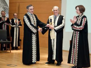 Ανωτέρω διακρίνεται ο κ. Κύρου παραλαμβάνων από τον κ. Καψάλη το Δίπλωμα, ενώ χειροκροτούν η κ. Λιάμπη και -αριστερά- οι κ.κ. Σταυράκος και Λώλος. 